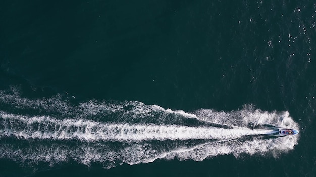 Vue aérienne dynamique du scooter des mers ou de la motomarine ou du jet de ski faisant la course à travers les vagues de la mer