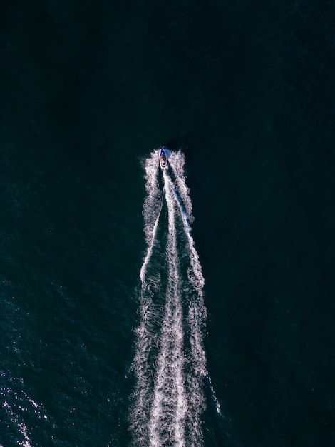 Vue aérienne dynamique du scooter des mers ou de la motomarine ou du jet de ski faisant la course à travers les vagues de la mer