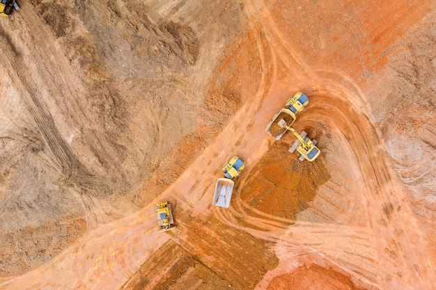 Photo vue aérienne d'une excavatrice à chenilles industrielle en train de creuser la terre et de la verser dessus