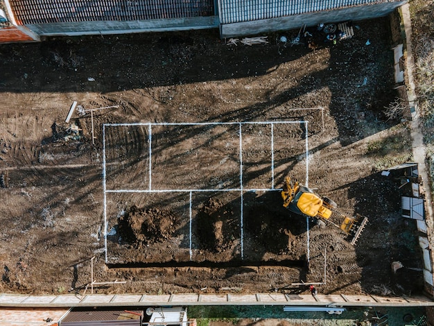 Vue aérienne d'une excavatrice creusant des fondations sur un chantier de construction