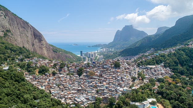 Vue aérienne de Favela da Rocinha, du plus grand bidonville du Brésil sur la montagne à Rio de Janeiro et de la silhouette de la ville derrière