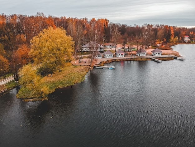 Vue aérienne de la forêt et du lac bleu. Sauna house au bord du lac. Jetée en bois avec des bateaux de pêche. Saint-Pétersbourg, Russie.