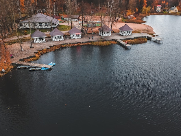 Vue aérienne de la forêt et du lac bleu. Sauna house au bord du lac. Jetée en bois avec des bateaux de pêche. Saint-Pétersbourg, Russie.