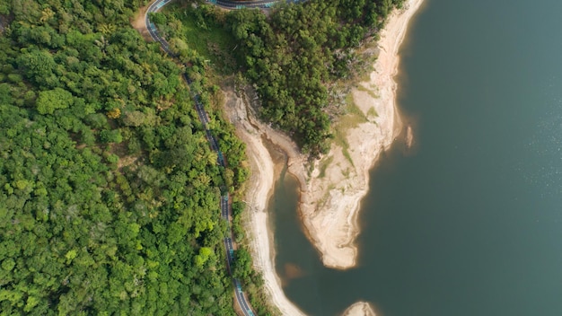 Vue aérienne de la forêt tropicale humide avec une route goudronnée autour du barrage