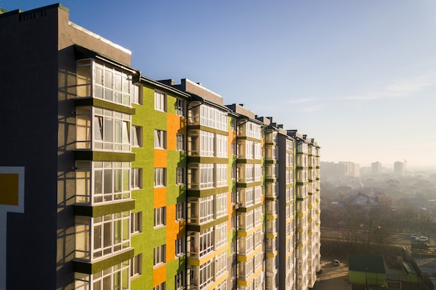 Vue aérienne d'un grand immeuble résidentiel avec de nombreuses fenêtres et balcons.