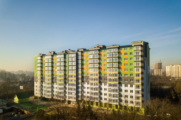 Vue aérienne d'un grand immeuble résidentiel avec de nombreuses fenêtres et balcons.