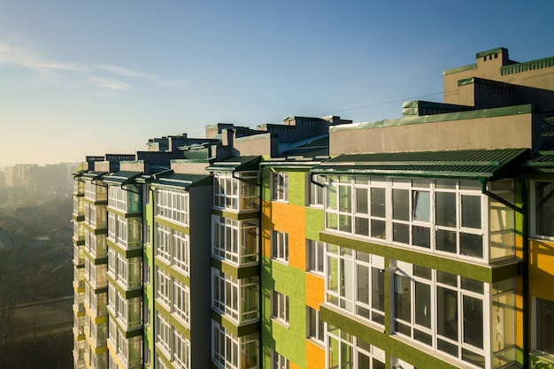 Vue aérienne d'un grand immeuble résidentiel avec de nombreuses fenêtres et balcons.