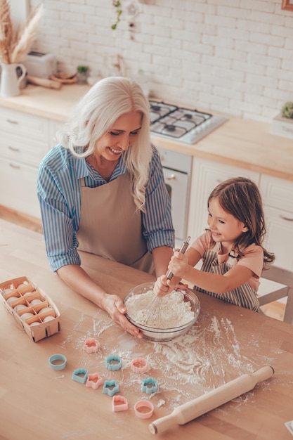 Vue aérienne de la grand-mère et de la petite-fille préparant la pâte pour les biscuits