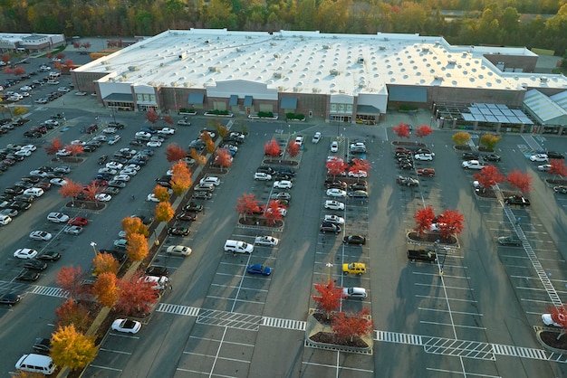 Photo vue aérienne d'un grand parking devant le magasin de rgocery avec de nombreuses voitures colorées garées parking au centre commercial supercenter avec des lignes et des marques pour les emplacements et les directions des véhicules