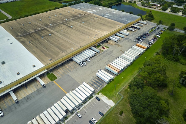Vue aérienne d'une grande baie de chargement commerciale avec de nombreux camions de livraison déchargant et chargant des marchandises de détail pour une distribution nationale Concept d'économie mondiale