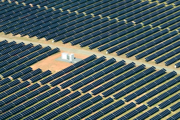 Vue aérienne d'une grande centrale électrique durable avec de nombreuses rangées de panneaux photovoltaïques solaires pour la production d'énergie électrique propre Electricité renouvelable avec concept d'émission zéro