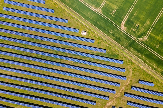 Vue aérienne d'une grande centrale électrique durable avec de nombreuses rangées de panneaux solaires photovoltaïques