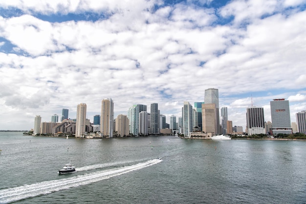 Vue aérienne des gratte-ciel de Miami avec ciel bleu nuageux, bateau blanc naviguant à côté du centre-ville de Miami