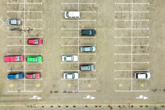 Vue aérienne de haut en bas de nombreuses voitures sur un parking de supermarché ou sur le marché des concessionnaires automobiles.