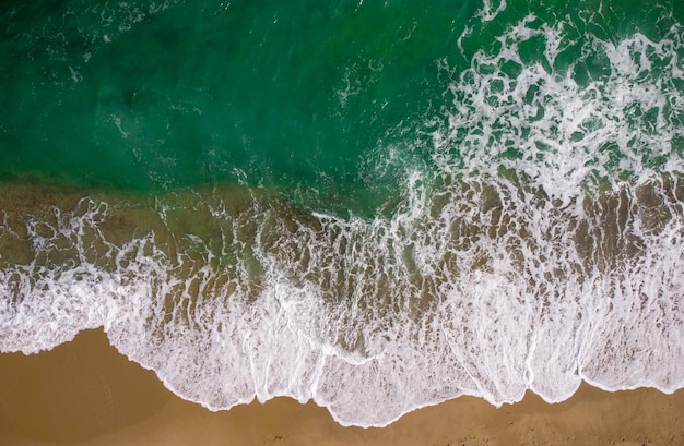 Vue aérienne de haut en bas sur une plage de sable avec vue sur la mer