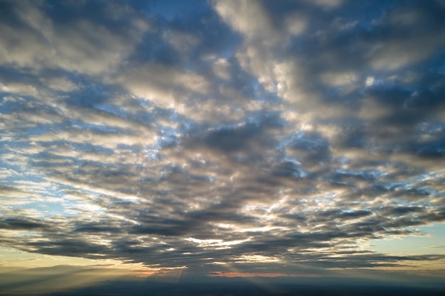 Vue aérienne d'en haut à haute altitude de denses cumulus gonflés volant en soirée Incroyable coucher de soleil du point de vue de la fenêtre de l'avion