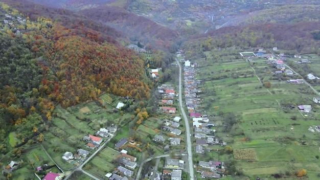 Vue aérienne de la hauteur du beau village rural avec des maisons et des rues sur terrain labouré
