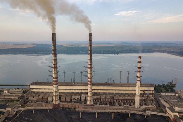 Vue aérienne de hauts tuyaux de cheminée avec de la fumée grise de la centrale électrique au charbon. Production d'électricité à partir de combustibles fossiles.