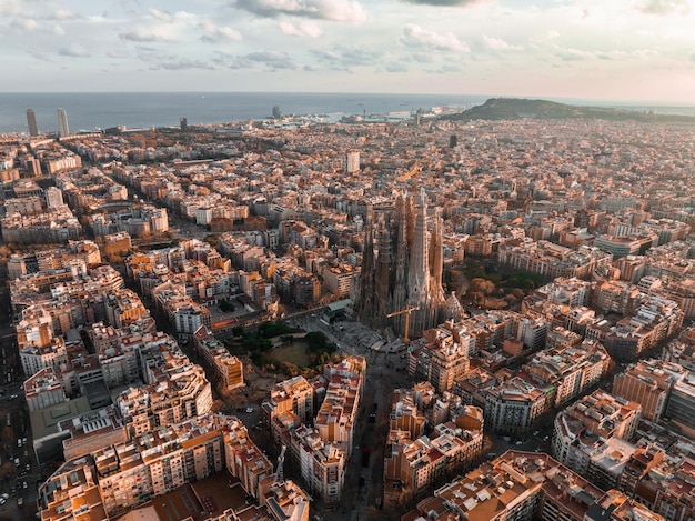 Photo vue aérienne de l'horizon de la ville de barcelone et de la cathédrale de la sagrada familia au coucher du soleil