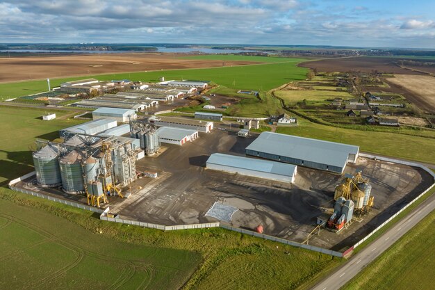 Vue aérienne d'un immense complexe agro-industriel avec silos et ligne de séchage de grains