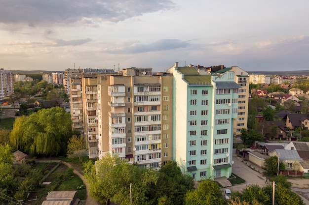 Vue aérienne d'immeubles à plusieurs étages dans un quartier résidentiel verdoyant.