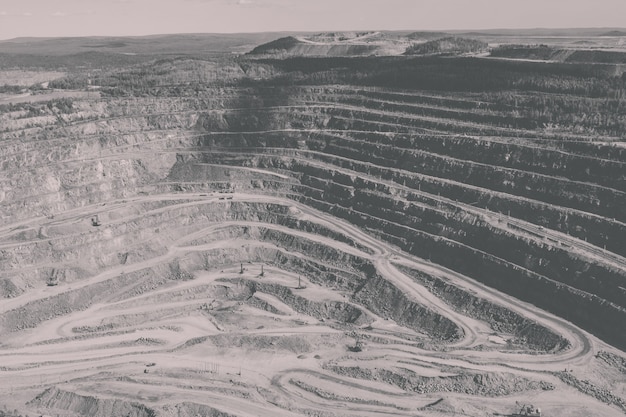 Vue aérienne industrielle de la carrière minière à ciel ouvert avec beaucoup de machines au travail - vue d'en haut. Extraction de chaux, craie, chaux, charbon