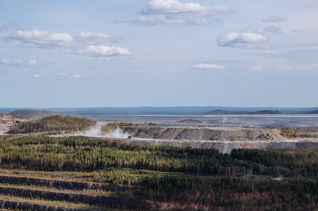 Vue aérienne industrielle de la carrière minière à ciel ouvert avec beaucoup de machines au travail - vue d'en haut. Extraction de chaux, craie, chaux, charbon