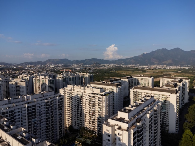 Vue aérienne de Jacarepagua à Rio de Janeiro Brésil Bâtiments résidentiels et montagnes autour du lac Plage de Barra da Tijuca en arrière-plan Journée ensoleillée Photo de drone