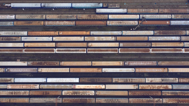 Vue aérienne de la jonction ferroviaire à plusieurs voies avec trains, passagers et wagons de marchandises. Dépôt de wagons.