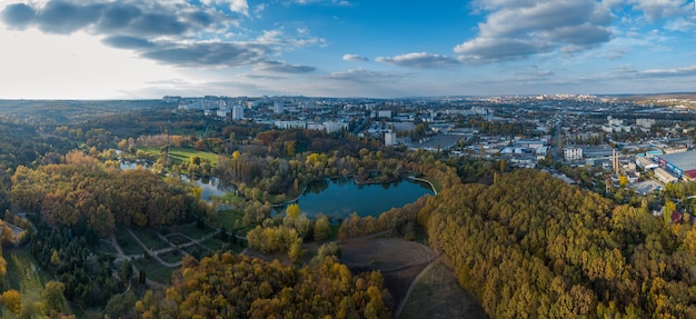 Vue aérienne d'un lac dans un parc aux arbres d'automne. Kichinev, Moldavie. Vol aérien épique au-dessus de l'eau. Arbres d'automne colorés pendant la journée.