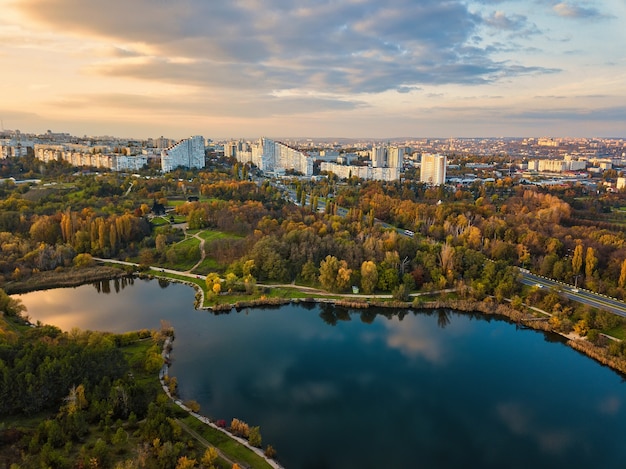 Vue aérienne d'un lac dans un parc aux arbres d'automne. Kichinev, Moldavie. Vol aérien épique au-dessus de l'eau. Arbres d'automne colorés pendant la journée.