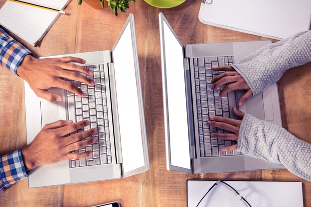 Vue aérienne des mains en tapant sur un clavier d&#39;ordinateur portable au bureau au bureau créatif