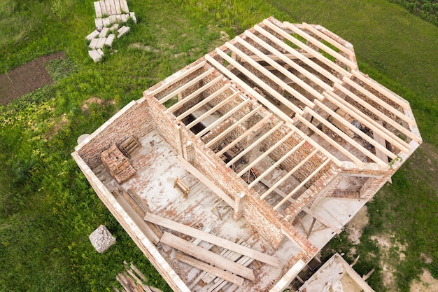 Vue aérienne d'une maison en brique avec cadre de plafond en bois en construction.