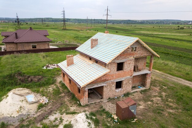 Vue aérienne d'une maison en brique avec charpente en bois en construction.