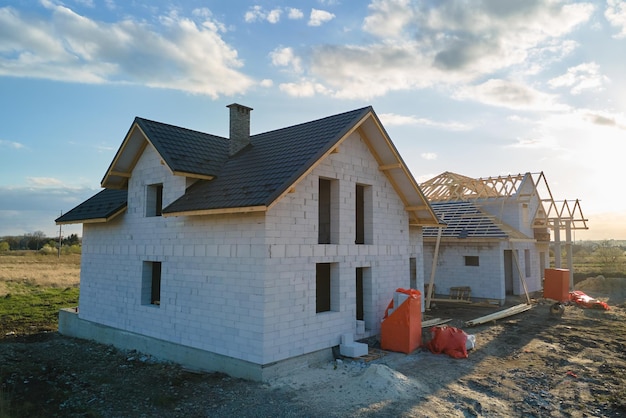 Photo vue aérienne d'une maison inachevée avec des murs en béton léger aéré et une charpente en bois recouverte de tuiles métalliques en construction