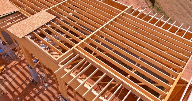 Vue aérienne d'une maison à ossature bois de charpente de poutres en bois sur bâton construit maison en construction nouveau