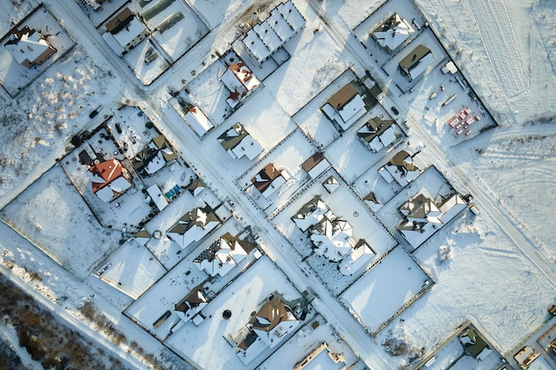 Vue aérienne de maisons d'habitation avec des toits couverts de neige dans la ville rurale de banlieue en hiver