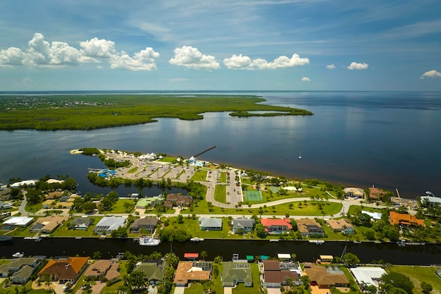 Vue aérienne de maisons privées rurales dans des banlieues éloignées situées sur la côte maritime près de la Floride zones humides de la faune avec une végétation verte sur la rive de la baie du golfe Vivre près de la nature dans le concept de région tropicale