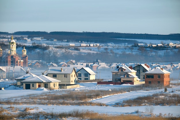 Vue aérienne de maisons privées avec des toits couverts de neige dans les banlieues rurales de la ville en hiver froid