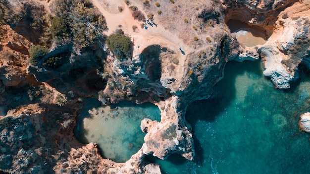 Vue aérienne de la mer entourée de falaises sous la lumière du soleil en Algarve, Portugal