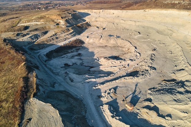 Vue aérienne de la mine à ciel ouvert de matériaux de grès pour l'industrie de la construction avec des excavatrices et des camions à benne basculante Équipement lourd dans l'exploitation minière et la production de concept de minéraux utiles