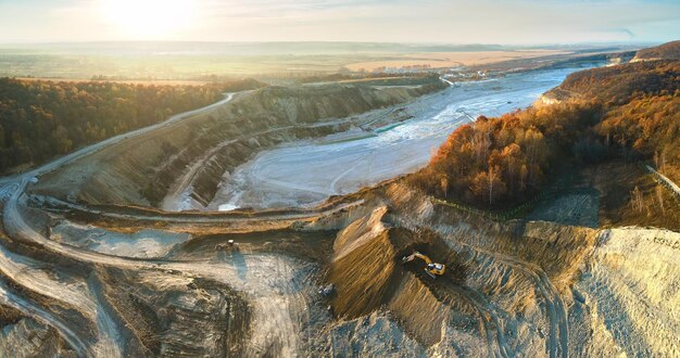 Vue aérienne de la mine à ciel ouvert de matériaux de grès pour l'industrie de la construction avec des excavatrices et des camions à benne basculante Équipement lourd dans l'exploitation minière et la production de concept de minéraux utiles