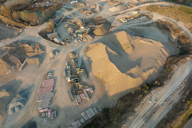 Vue aérienne de la mine à ciel ouvert de matériaux de grès pour l'industrie de la construction avec des excavatrices et des camions à benne basculante Équipement lourd dans l'exploitation minière et la production de concept de minéraux utiles