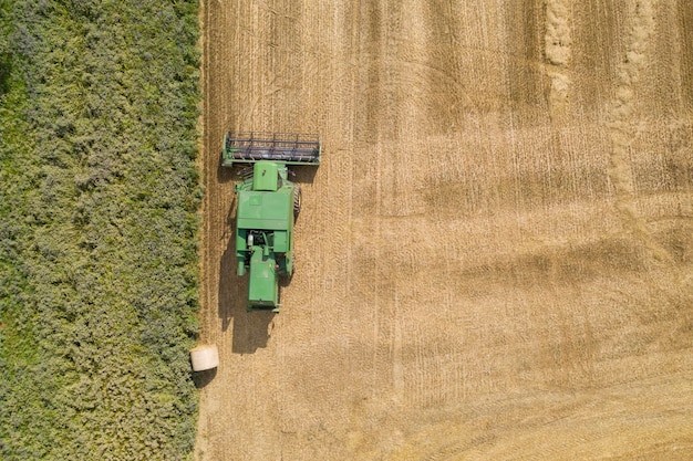 Vue aérienne sur une moissonneuse-batteuse verte dans un champ agricole