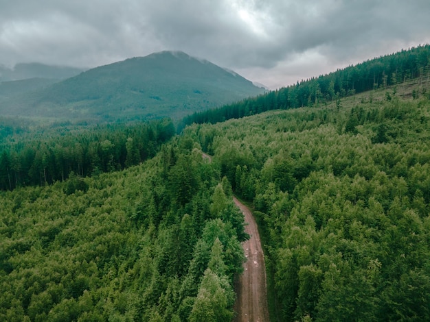 Vue aérienne des montagnes des carpates par temps couvert voiture suv sur la route du sentier