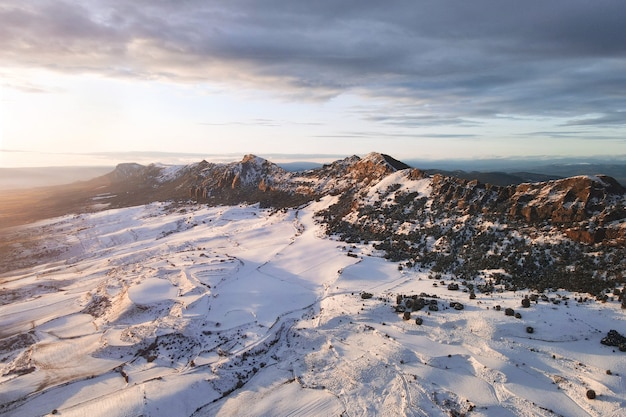 Vue aérienne des montagnes couvertes de neige au coucher du soleil