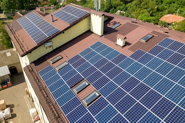 Vue aérienne de nombreux panneaux solaires montés sur le toit d'un bâtiment industriel.