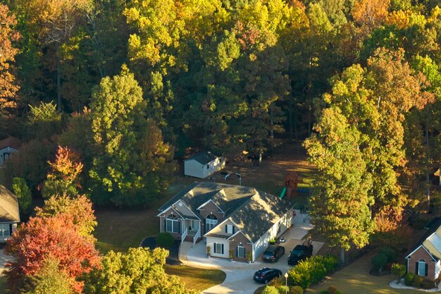 Vue aérienne d'une nouvelle maison familiale entre des arbres jaunes dans la banlieue de la Caroline du Sud à l'automne. Développement immobilier dans les banlieues américaines