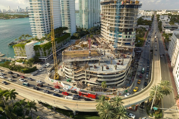 Photo vue aérienne de la nouvelle résidence en développement dans la zone urbaine américaine grues à tour sur le site de construction industrielle à miami en floride concept de croissance du logement aux états-unis