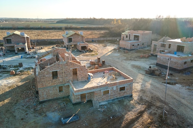 Vue aérienne de nouvelles maisons avec des murs à ossature de briques en construction dans la banlieue rurale Développement de l'immobilier dans les banlieues modernes de la ville